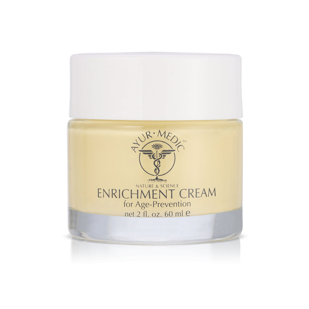 Enrichment Cream. Yellow cream inside a clear glass jar with white lid.