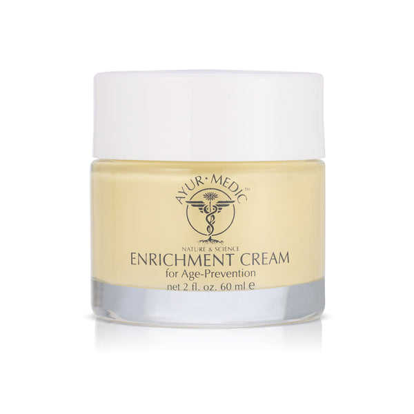 Enrichment Cream. Yellow cream inside a clear glass jar with white lid.
