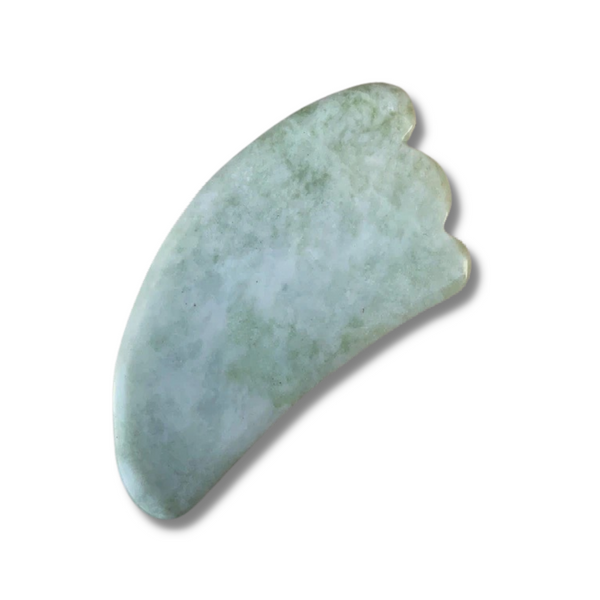 Serpentine stone shaped into an ergonomic facial massaging tool, featuring a scalloped edge on the wide end of the tool.